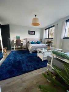 1 dormitorio con cama y alfombra azul en Appartement indépendant 30 m² à 500m du lac, 2 vélos et parking fournis, en Sévrier