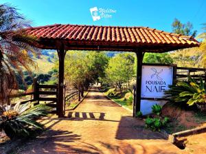 um pavilhão com um sinal ao lado de uma estrada em Pousada NAIF em São Lourenço