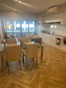 un soggiorno con tavolo e sedie e una cucina di Kingston Foreshore-Kingsborough a Kingston 