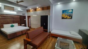 a small room with two beds and a couch at THE PALM SUITES , Incredible North East Tourism , Couples & Family in Guwahati