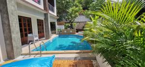 a swimming pool in front of a house at DB Studios Samui in Lamai
