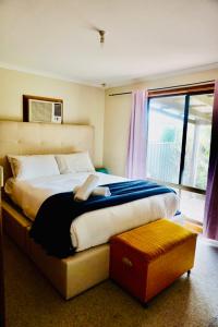 a bedroom with a large bed and a window at Decades in Port Willunga