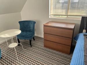 um quarto com uma secretária, uma cadeira azul e uma cómoda em Large One Bedroom on City Farmland em Longview