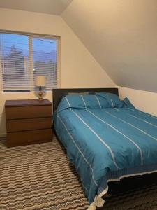 um quarto com uma cama azul e uma janela em Large One Bedroom on City Farmland em Longview