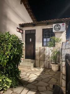 a front door of a house with a clock on it at Pousada Recanto da Vila in Pirenópolis