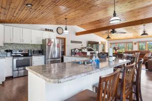 a kitchen with a large counter with chairs in it at Papa’s Place on Willow Creek in Custer