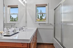 a white bathroom with two sinks and a shower at Papa’s Place on Willow Creek in Custer
