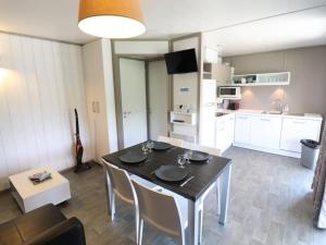 ein Wohnzimmer mit einem Tisch und Stühlen sowie eine Küche in der Unterkunft Gîte Le Rouget-Pers, 3 pièces, 4 personnes - FR-1-742-342 in Le Rouget