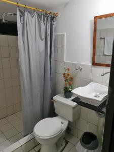 een badkamer met een toilet en een wastafel bij Finca Los Guayacanes in Tena