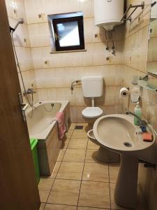 La salle de bains est pourvue d'un lavabo, de toilettes et d'une baignoire. dans l'établissement Apartment Dragi - 250 m from beach, à Supetar