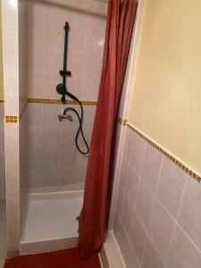 uma casa de banho com uma cortina de chuveiro vermelha. em Chez Precillia et Fabrice em Montlaur