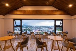 Una habitación con mesas y sillas y una gran ventana. en HT House, en Da Lat