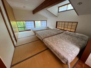 Muraoka的住宿－kakayama hutte，带2扇窗户的客房内的2张床