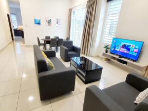 a living room with couches and a flat screen tv at JOVIAL SingleStorey Bungalow 4Room10Pax `Alma in Bukit Mertajam