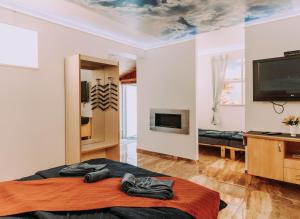 a room with a bed and a flat screen tv at Fenyvesi Villa in Balatonfenyves