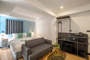 a hotel room with a bed and a couch at Myhotel Cmyk@Ratchada in Bangkok