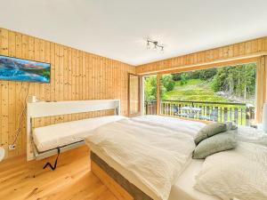 a bedroom with two beds and a large window at Pied de piste de Thyon - 4 Vallees in Vex