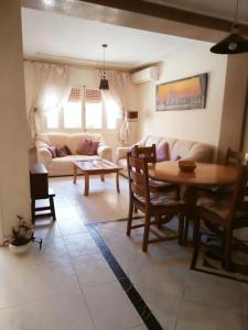 a living room with a table and a couch at Bel appartement plein centre avec double terrasse in Oujda
