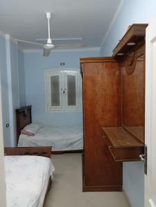 Kleines Zimmer mit 2 Betten und einem Schrank in der Unterkunft شارع ٨٩ فيلا ٢٤ in ‘Izbat al Burj