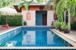 a swimming pool in front of a house at Ruen Thai Siray Green in Phuket