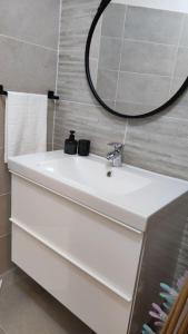 ein Badezimmer mit einem weißen Waschbecken und einem Spiegel in der Unterkunft Appartement Perpignan in Perpignan