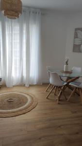 a living room with a table and a chair and a table and a rug at Appartement Perpignan in Perpignan