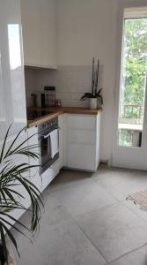 a white kitchen with a stove and a window at Appartement Perpignan in Perpignan