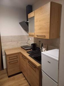 uma cozinha com um fogão e um frigorífico branco em Przytulny Apartament z Balkonem em Duszniki Zdrój
