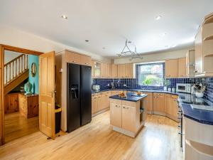 a kitchen with a black refrigerator and wooden cabinets at Welton House in Orby