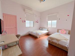 1 dormitorio con 2 camas, mesa y escritorio en Dan Bao Homestay, en Jincheng