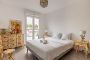 a white bedroom with a large bed and a window at L'échappée - T3 de 67 m2 - Grande terrasse - Quartier ultra secure in Metz