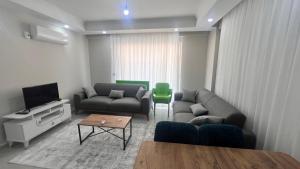 a living room with two couches and a tv at SELİNTİ CİTY DAİRE 1 Suit in Gazipasa