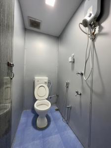 a bathroom with a toilet and a shower stall at FAMILIA INN in Kangar