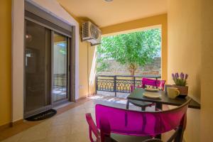 a dining room with purple chairs and a table on a balcony at ANNA'S APARTMENT in Alexandroupoli