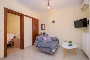 a living room with a chair and a tv at ANNA'S APARTMENT in Alexandroupoli