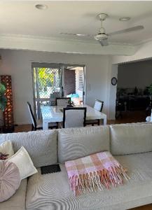 uma sala de estar com um sofá e uma sala de jantar em Room in a Family home em Gold Coast