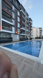 a person standing next to a swimming pool in a building at SELİNTİ CİTY DAİRE 1 Suit in Gazipasa