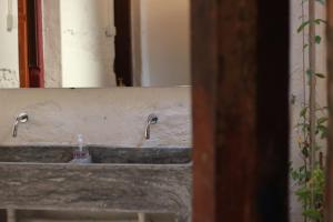 a bathroom sink with two faucets on it at The 80's Guesthouse in George Town