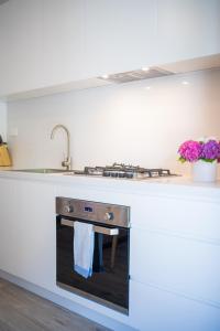 una cucina con piano cottura e lavandino di Crows Nest LemonTree Cozy 3 Bedroom House a Sydney