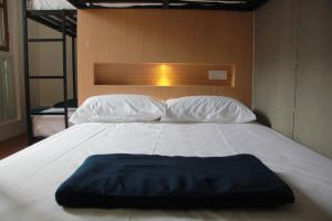 a white bed with two pillows on top of it at The 80's Guesthouse in George Town