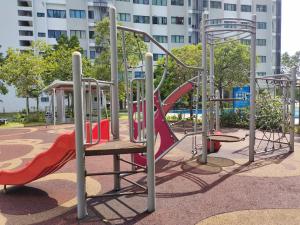 a playground with a red slide in a park at De Cozy Corner 2 Suria Rafflesia Setia Alam in Shah Alam
