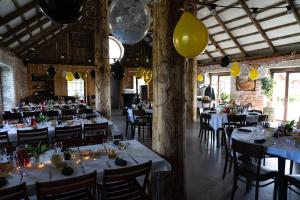 a dining room with tables and chairs and yellow balloons at Ratturi talu in Reigi