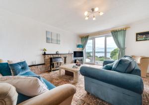 a living room with two blue couches and a fireplace at Sea View in Saundersfoot