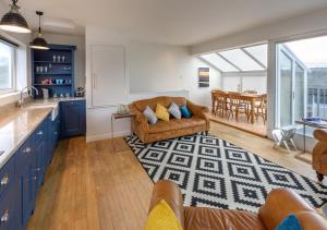a kitchen and living room with a couch and a table at 20 Cae Du in Abersoch