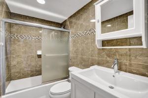 a bathroom with a toilet and a sink and a shower at 2Bd Condo Christmas Retreat Pool Beachside in Hollywood