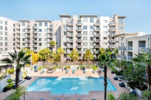 an apartment complex with a swimming pool and palm trees at Santa Clara 1BR w WD Gym SFO-835 in Santa Clara