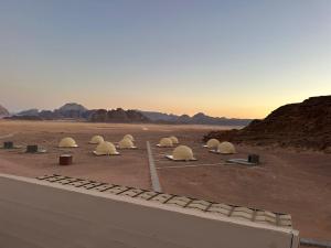 a group of domes in a desert with mountains at Amanda Luxury Camp in Wadi Rum