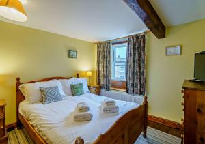 a bedroom with a bed with two towels on it at Marys Cottage in Hawes