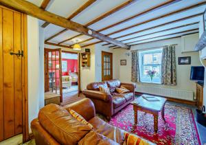 uma sala de estar com um sofá de couro e uma mesa em Marys Cottage em Hawes