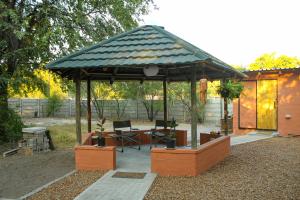 um gazebo com uma mesa e cadeiras num quintal em Casa Bena em Maun